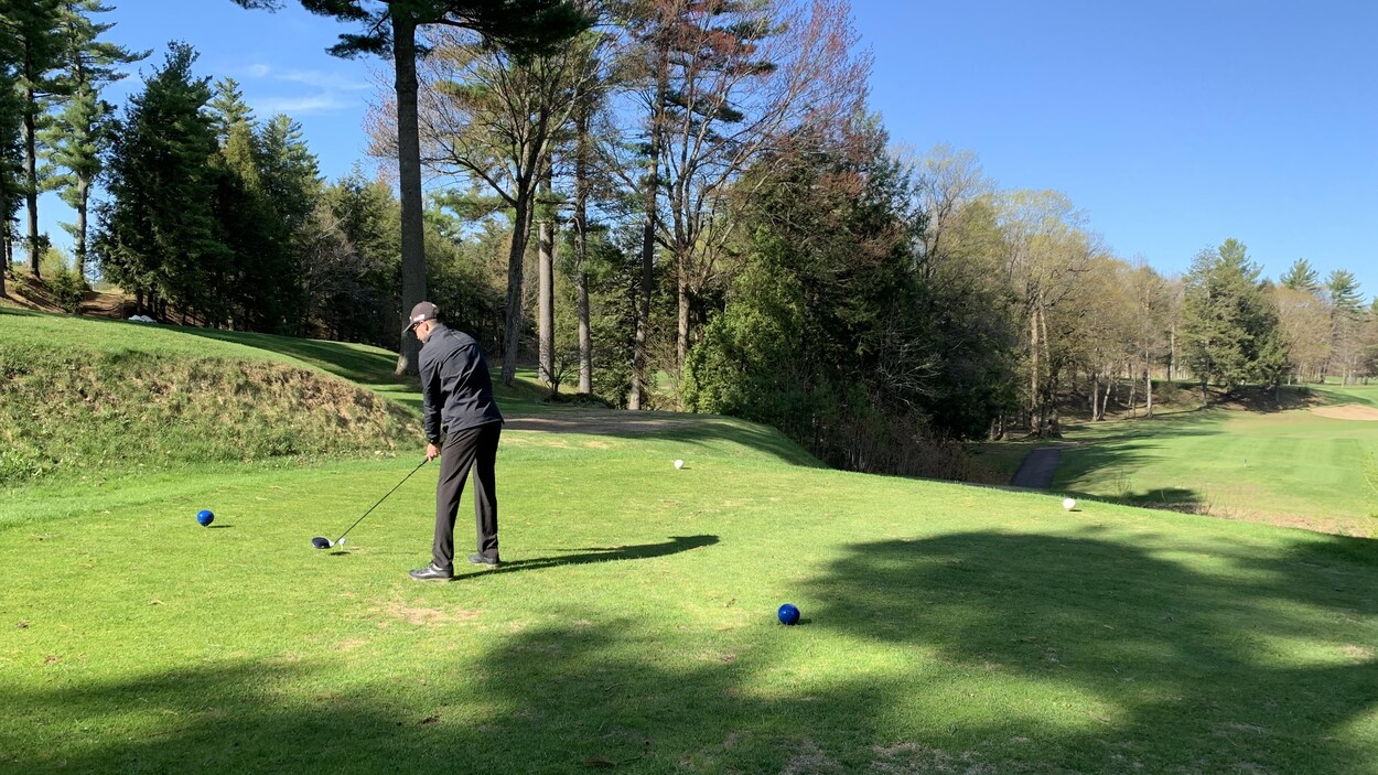 Un golfeur s'élance au départ d'un trou de golf.