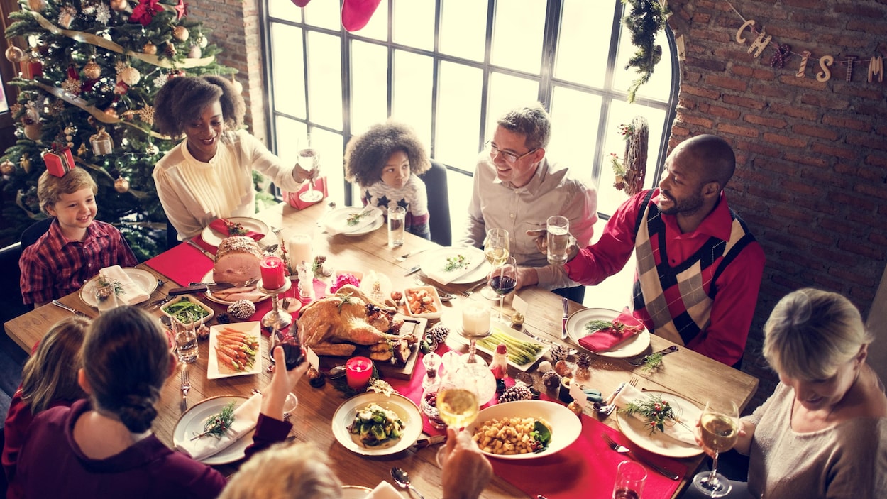 Une famille et des amis réunis autour d'une dinde du temps des Fêtes.