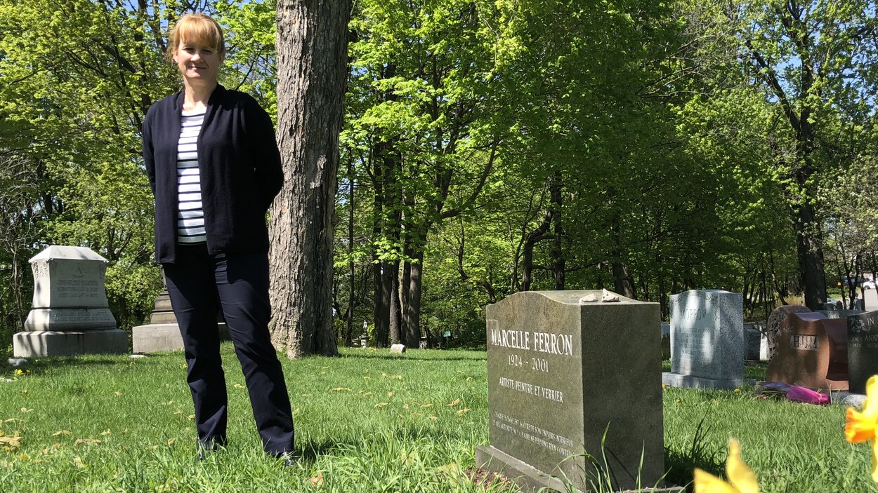 La directrice des programmes du patrimoine au Cimetière Mont-Royal de Montréal, Myriam Cloutier, devant la pierre tombale de la peintre Marcelle Ferron