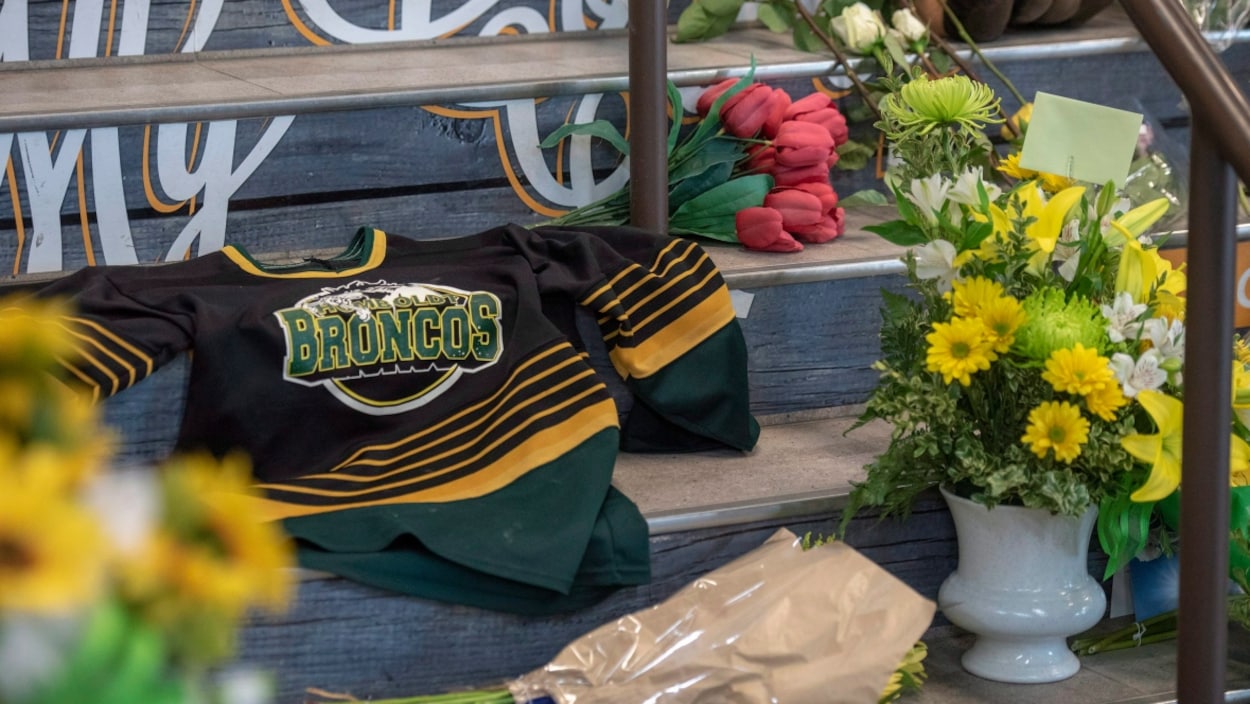 Un chandail de l'équipe des Broncos entouré de fleurs est placé sur des marches Un chandail de l'équipe des Broncos entouré de fleurs est placé sur des marches