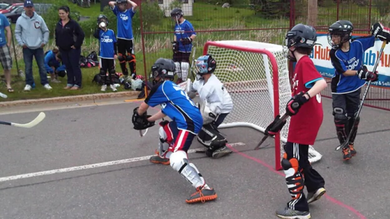 Des enfants jouent au hockey dans la rue.