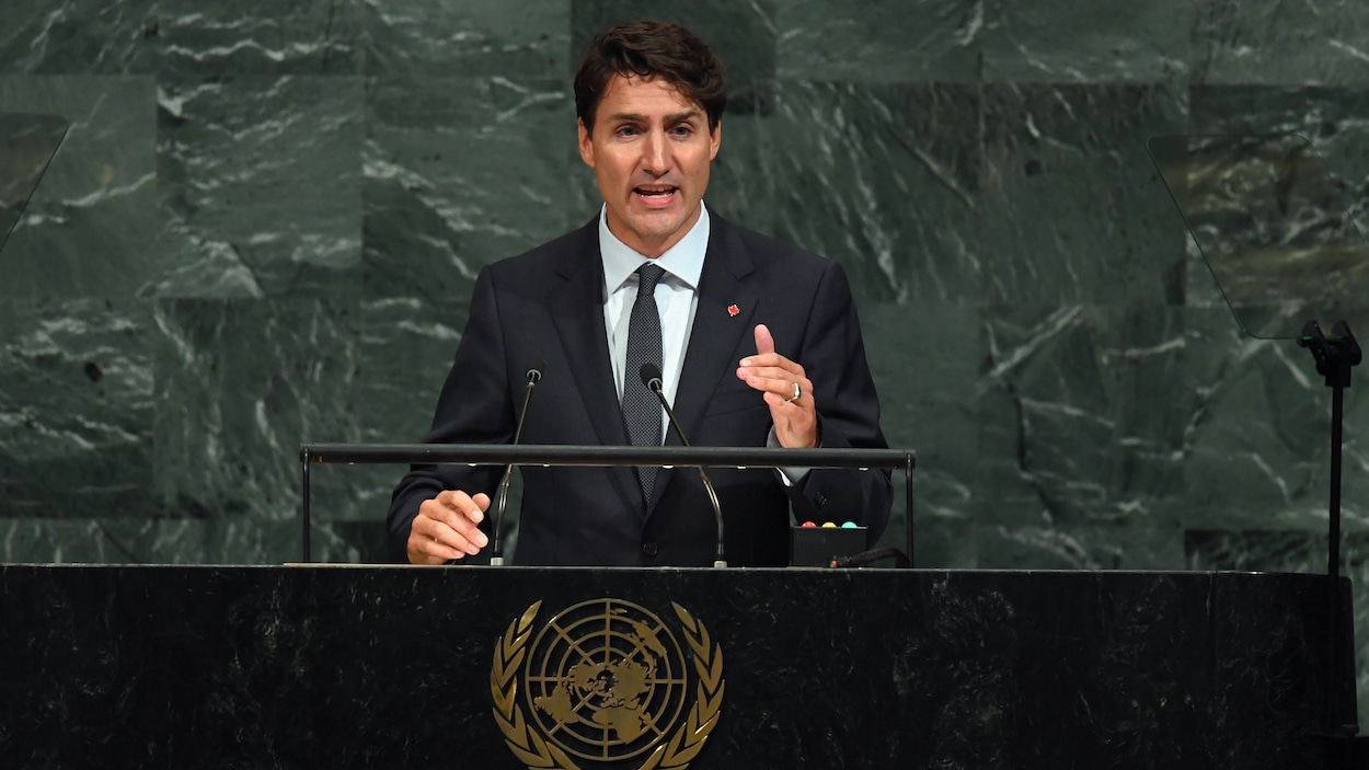 Justin Trudeau s'adresse aux délégués de l'ONU devant un mur en marbre.