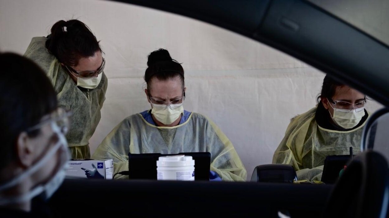Des infirmières en blouse en train de travailler.