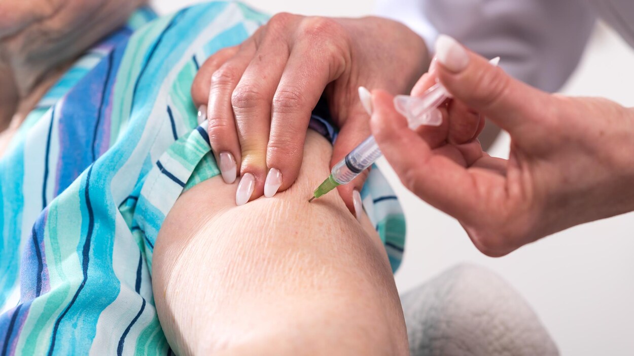 Une infirmière vaccine une personne âgée.