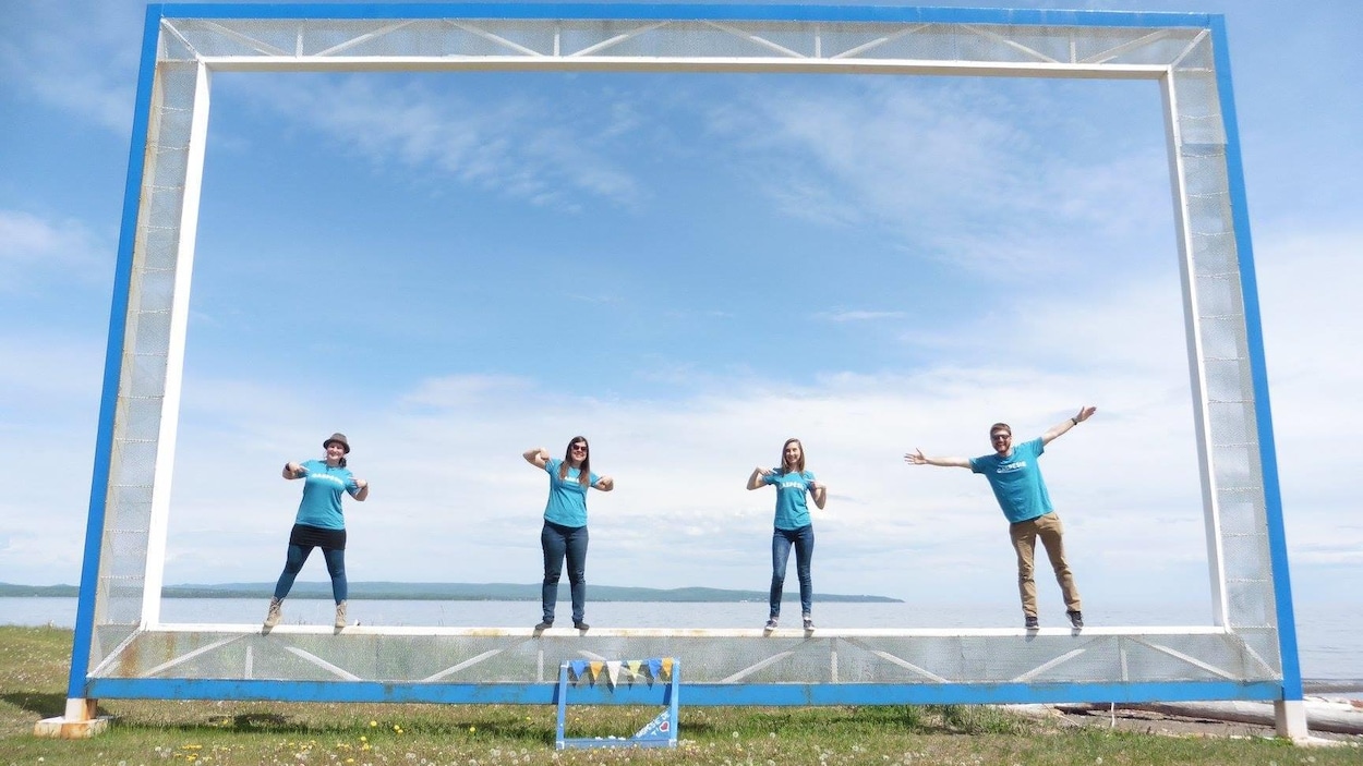 Quatre personnes vêtues de bleu se tiennent devant le fleuve.
