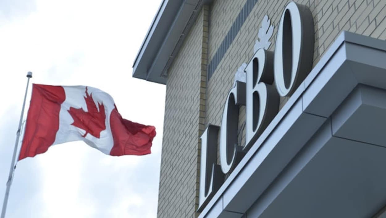 L'enseigne de la LCBO près d'un drapeau canadien qui flotte.