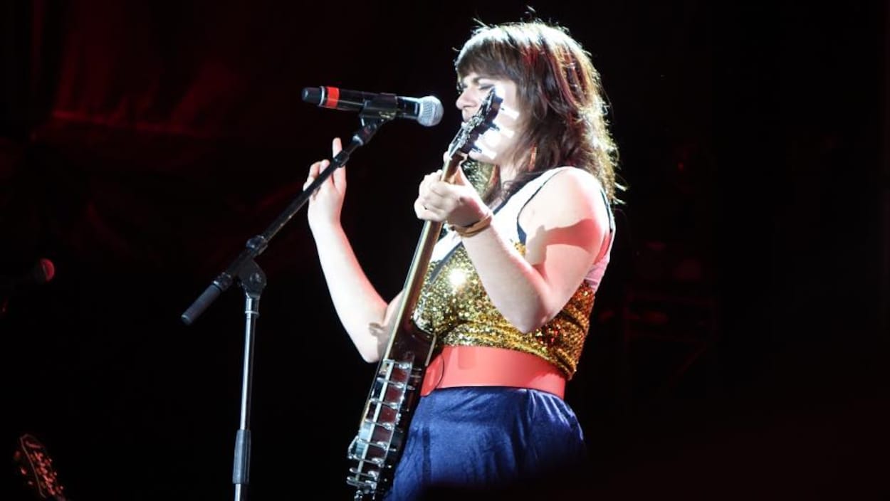 Lisa LeBlanc joue du banjo et chante sur scène. Lisa LeBlanc joue du banjo et chante sur scène.
