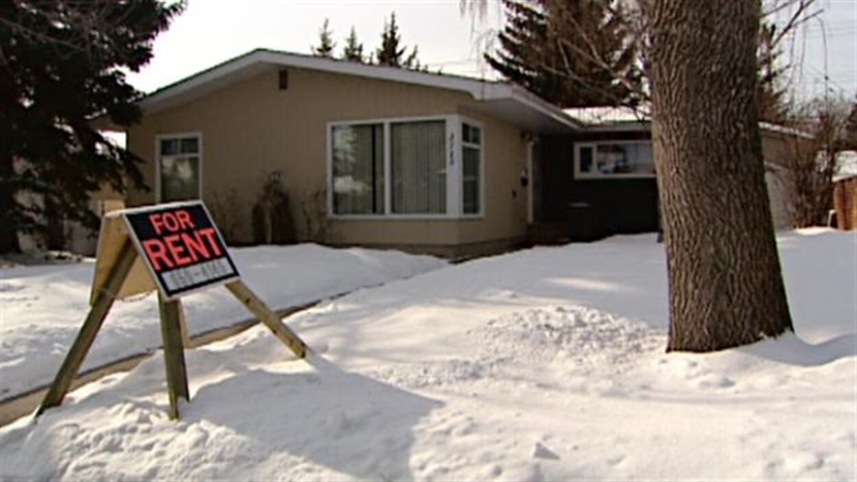 Un bungalow en hiver arborant une affiche à louer. Un bungalow en hiver arborant une affiche à louer.