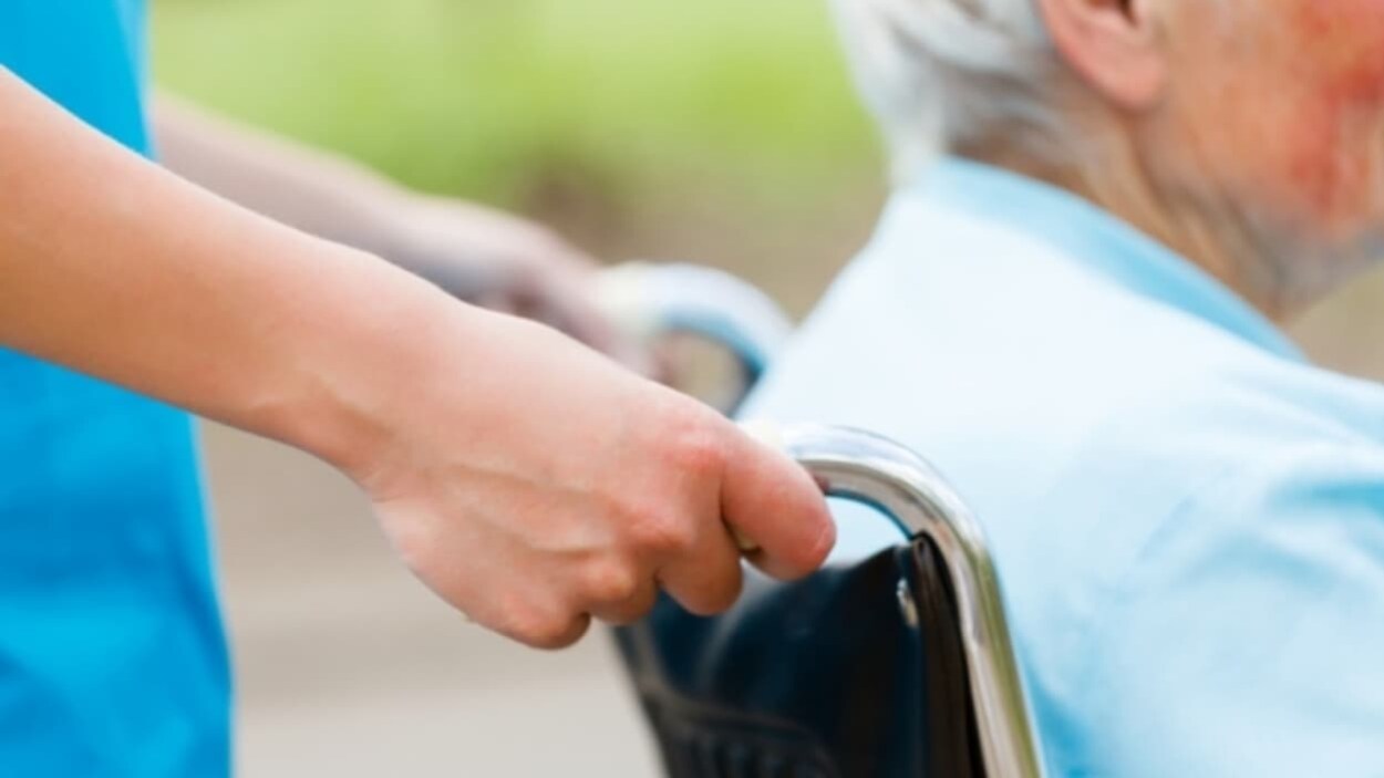 Un aîné est poussé dans un fauteuil roulant. Un aîné est poussé dans un fauteuil roulant.