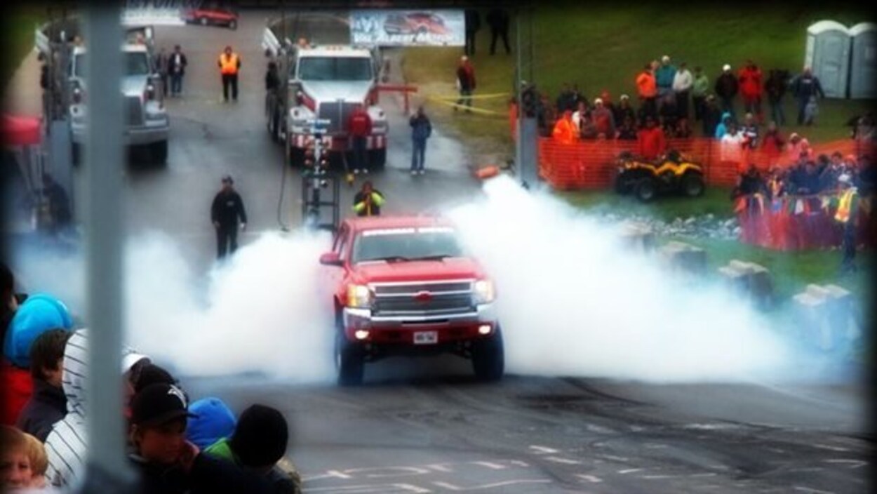 Une camionnette tire un grand camion lors d'une course au Smooth Truck Fest