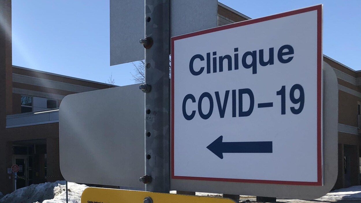 Une affiche indique la direction à prendre pour se rendre dans une clinique dédiée au dépistage de la COVID-19.