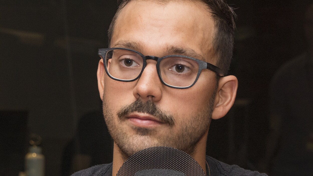 Un plan serré de Xavier Desharnais devant un micro