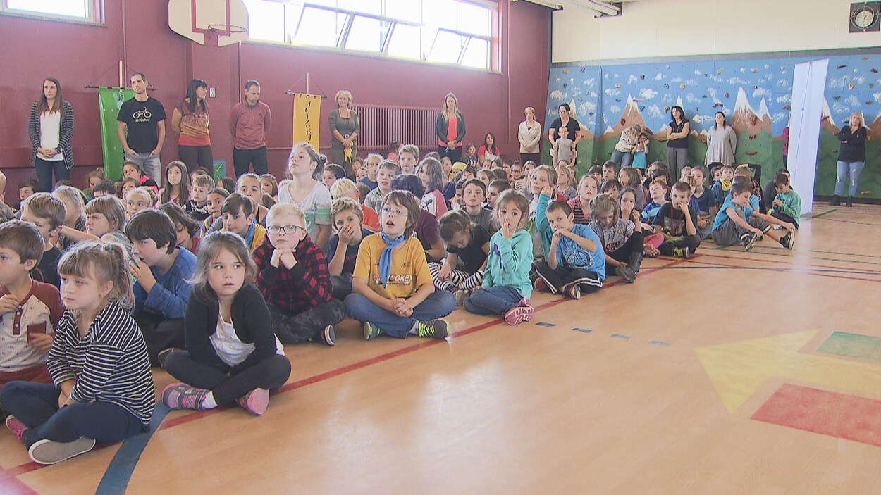 Assis dans le gymnase, une centaine d'élèves attendent le début de la conférence de presse. Assis dans le gymnase, une centaine d'élèves attendent le début de la conférence de presse.