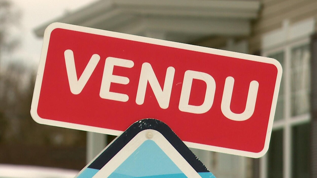 Une affiche d'agent immobilier qui indique la vente d'une maison à Québec.