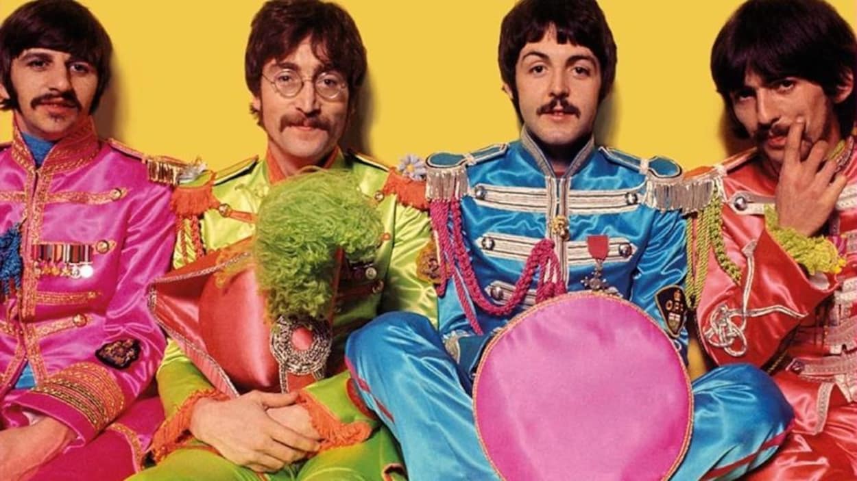 Les 4 membres du groupe The Beatle dans des costumes colorés.