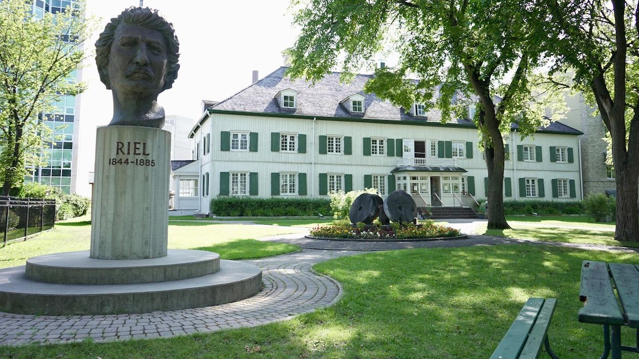 La tête en bronze de Riel trône devant un édifice historique.