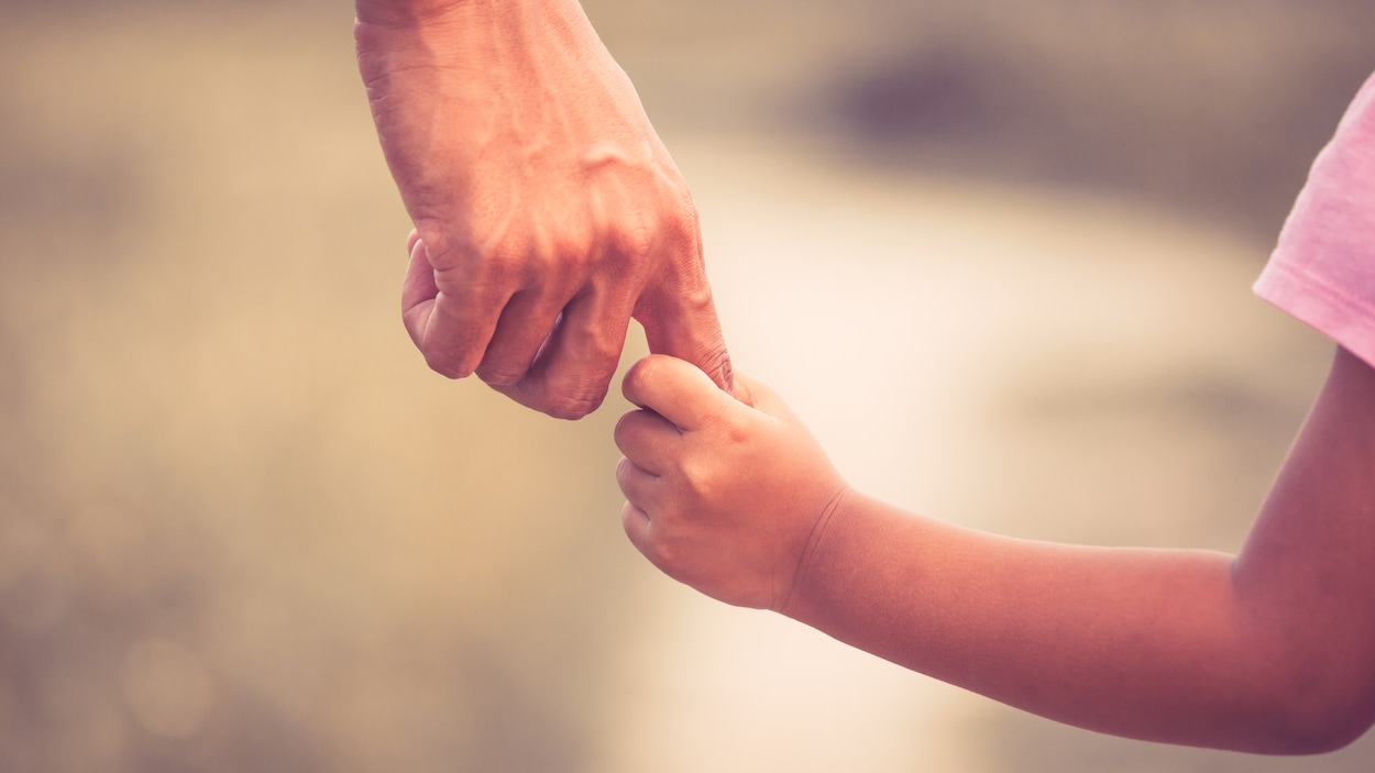 Une père et sa fille se prenant la main