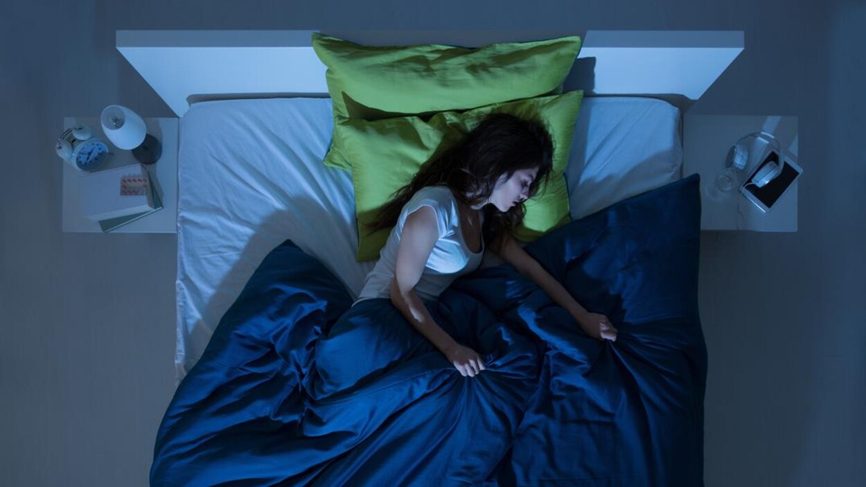 Une femme endormie seule dans un lit 