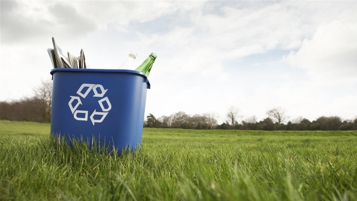 Un bac de recyclage déposé sur du gazon