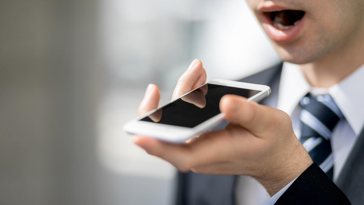 Un homme donne une commande à son téléphone.