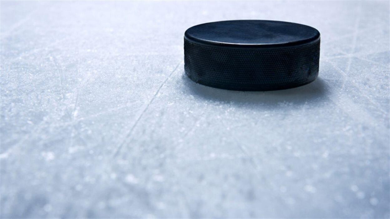 Une rondelle de hockey repose sur une patinoire.