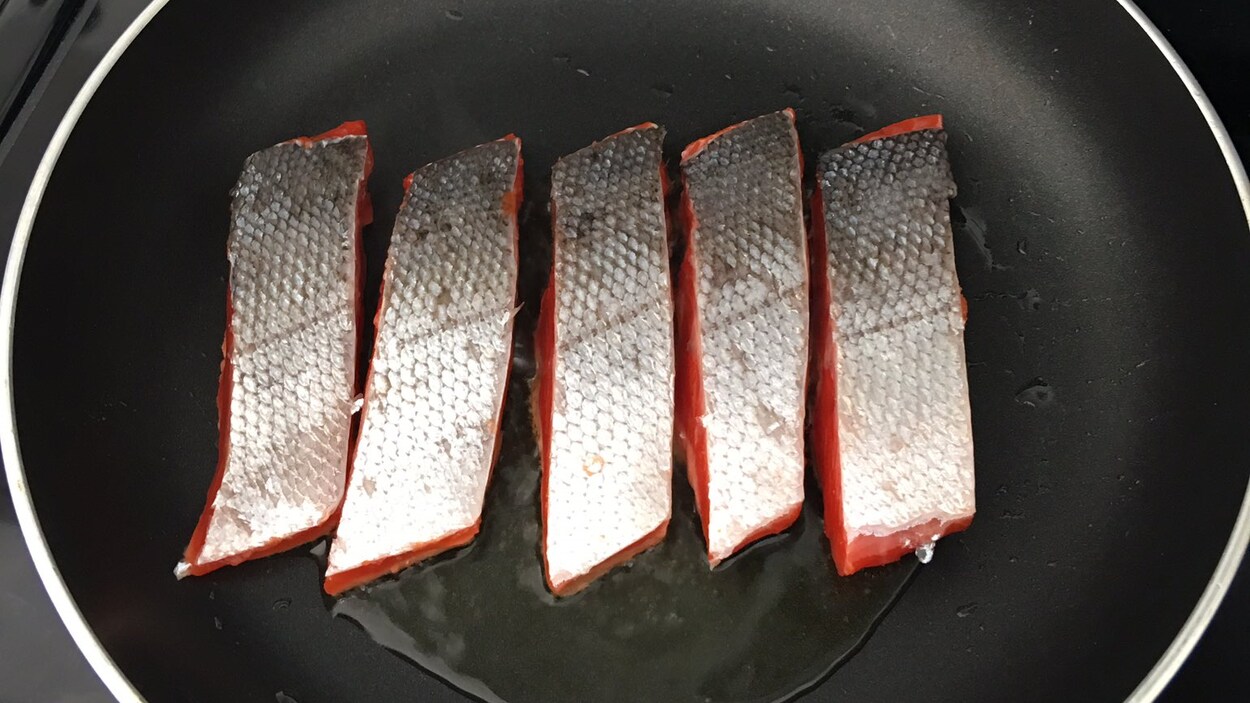 Du saumon qui grille dans un poêlon. Du saumon qui grille dans un poêlon.