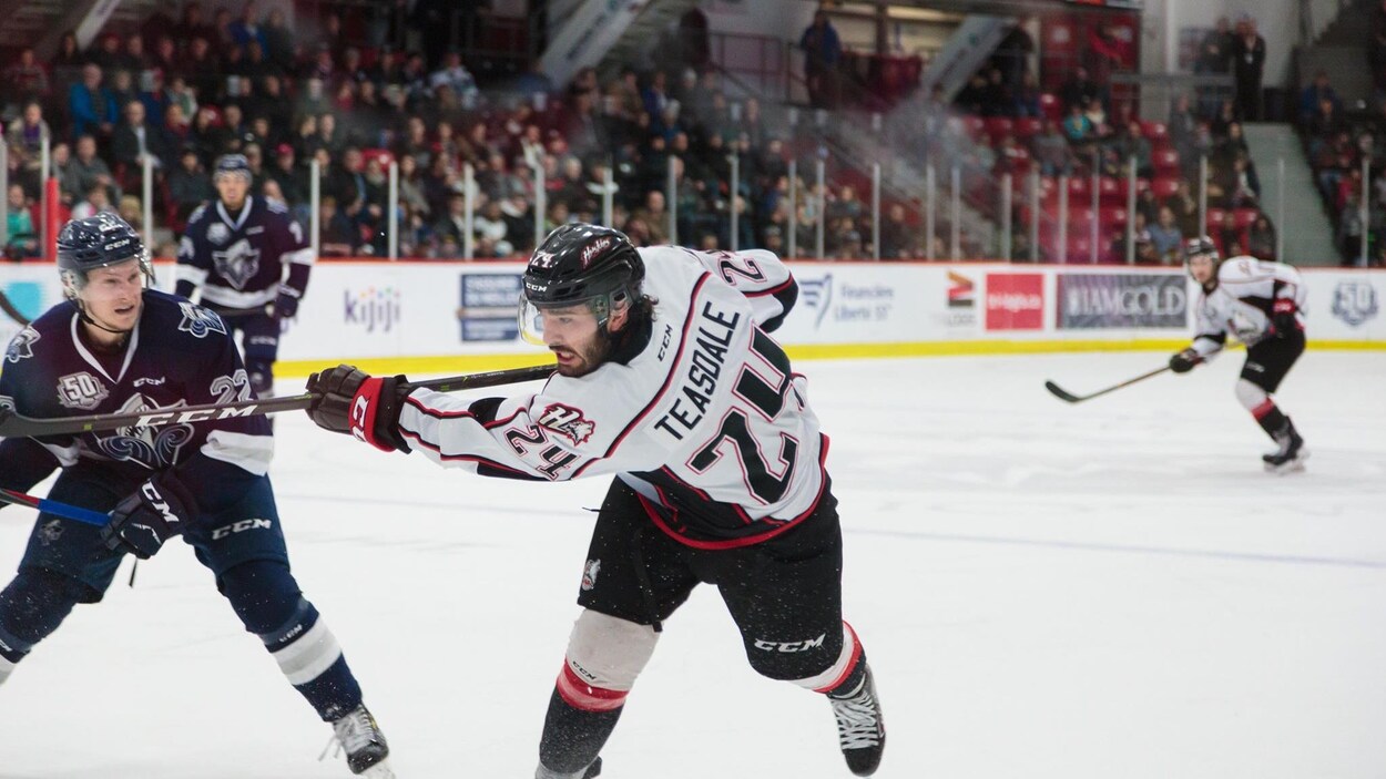 Un joueur de hockey effectue un tir au but.