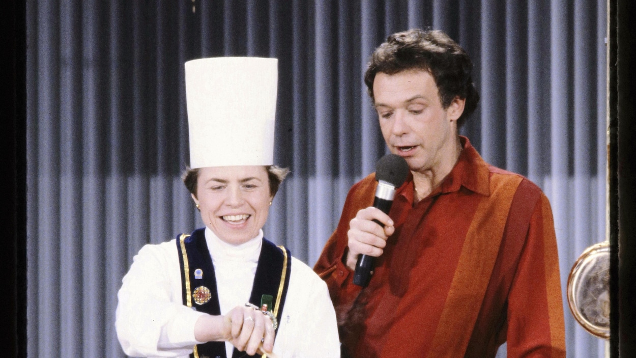 Soeur Angèle brassant une marmite tout en parlant à l'animateur d'Allô Boubou Jacques Boulanger.
