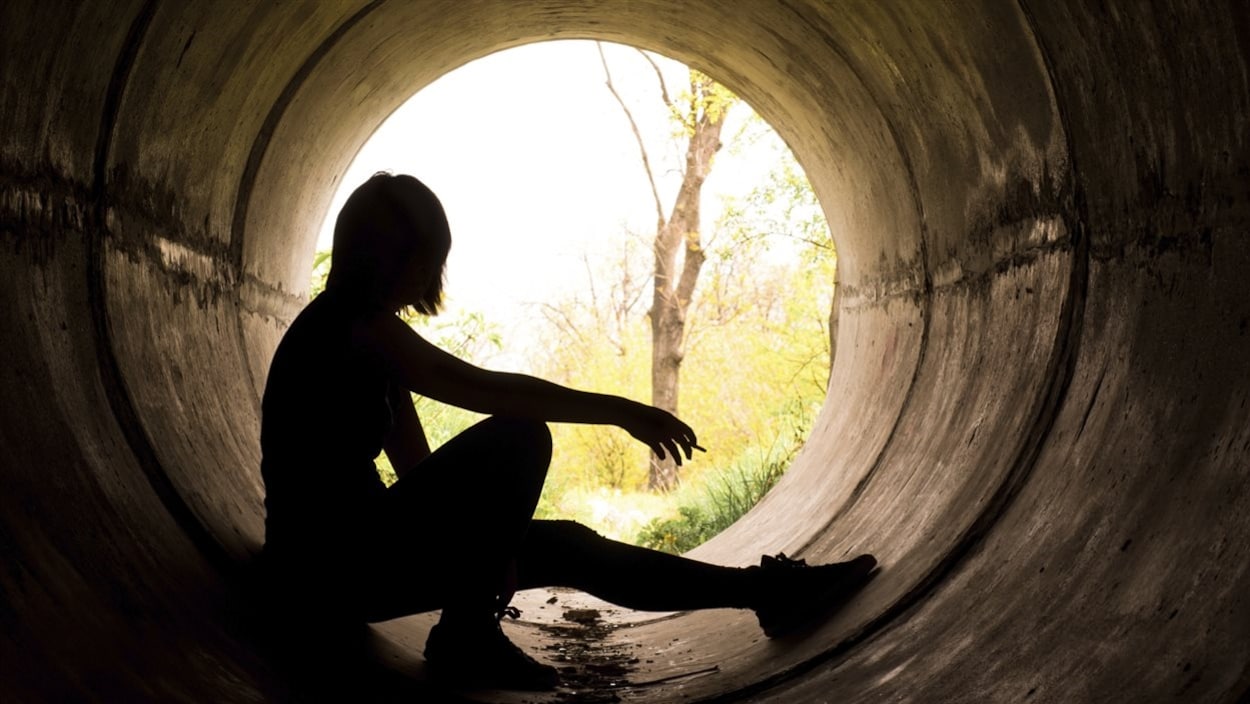 Silhouette d'une jeune fille assise dans un tunnel. Silhouette d'une jeune fille assise dans un tunnel.