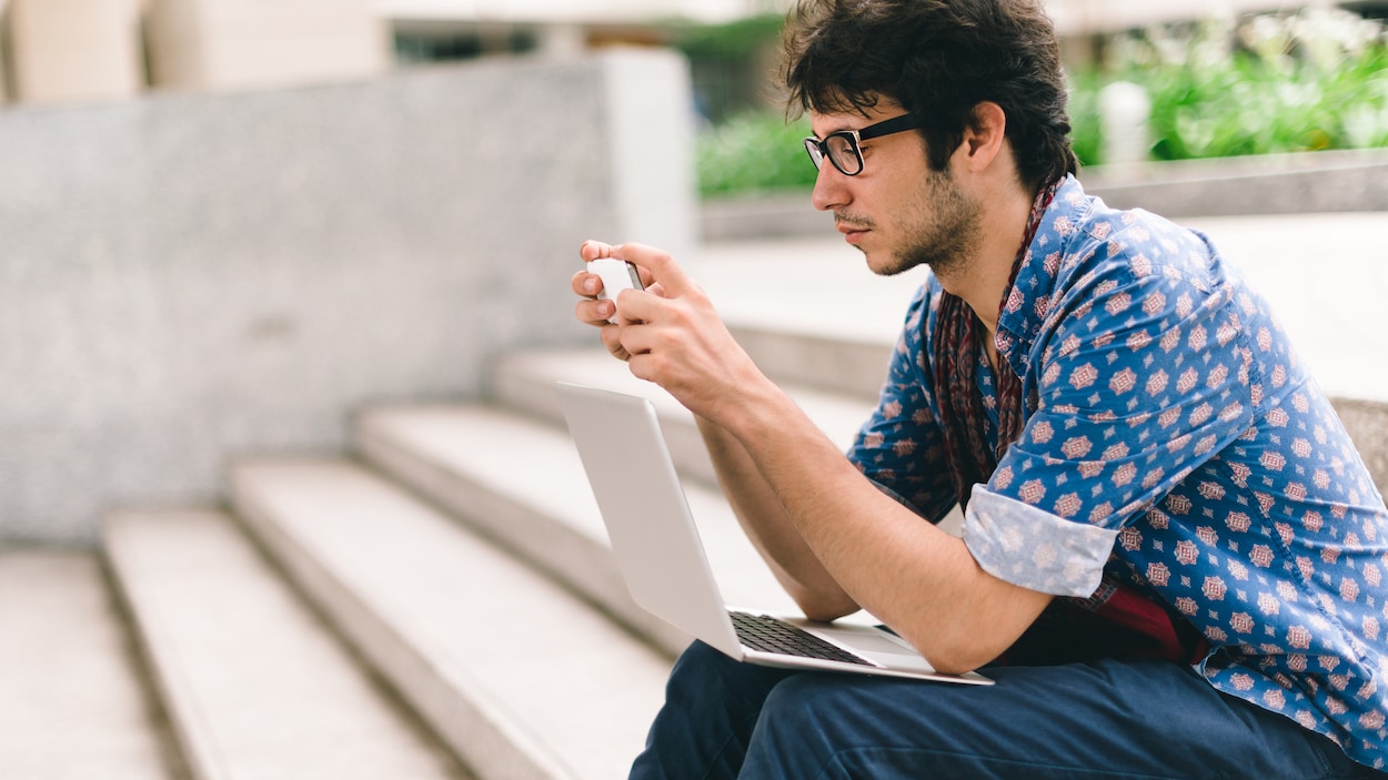 Une jeune consulte de l'information sur son téléphone.
