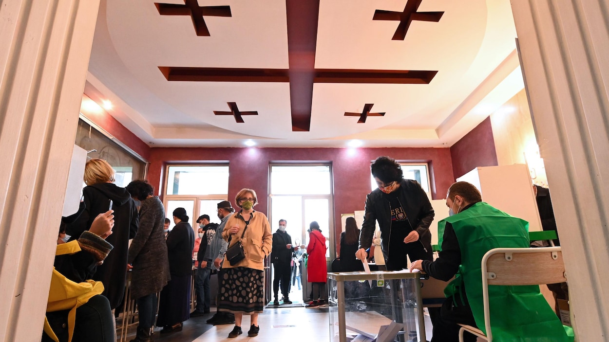Des Géorgiens viennent déposer le bulletin de vote, dans un bureau de vote de la capitale Tbilisi, le 31 octobre.