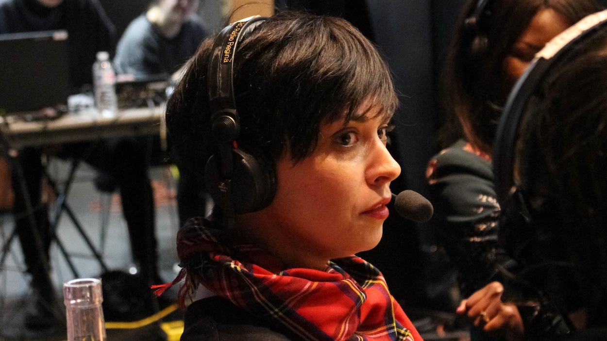 La jeune femme porte un casque et regarde la personne à côté d'elle.