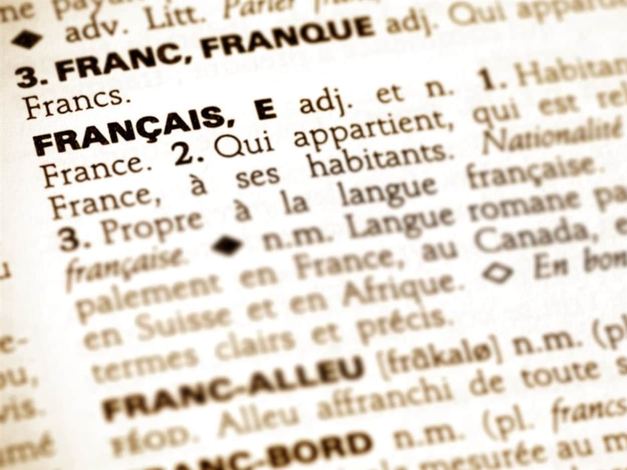 Un gros plan sur une page de dictionnaire montrant les définitions du mot français. Un gros plan sur une page de dictionnaire montrant les définitions du mot français.