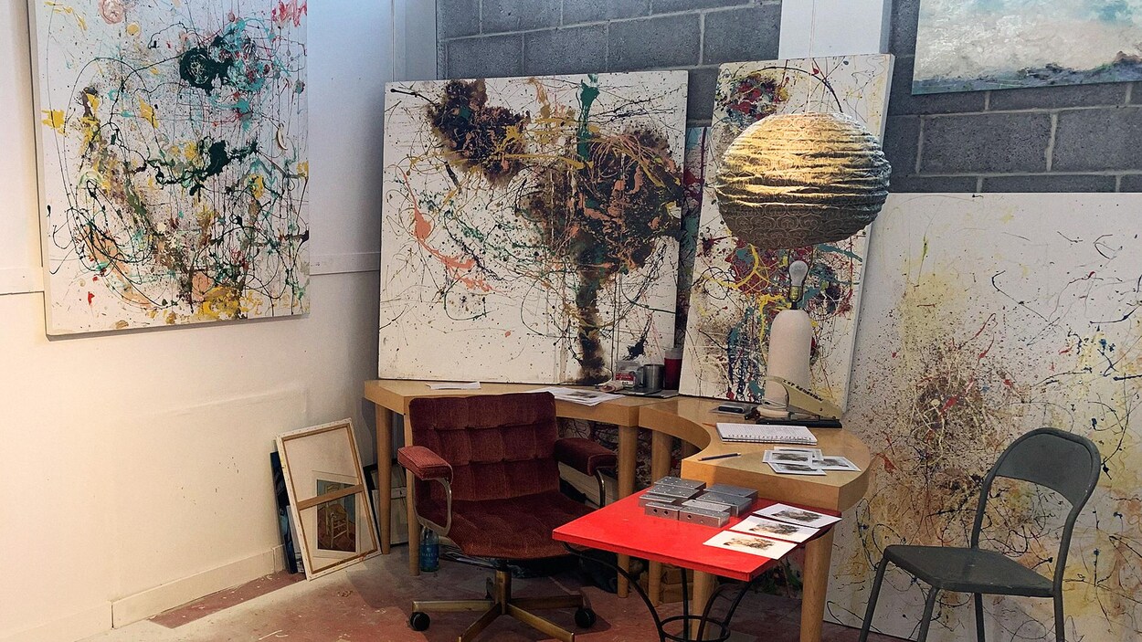 Un atelier d'artiste avec plusieurs toiles dans un studio.