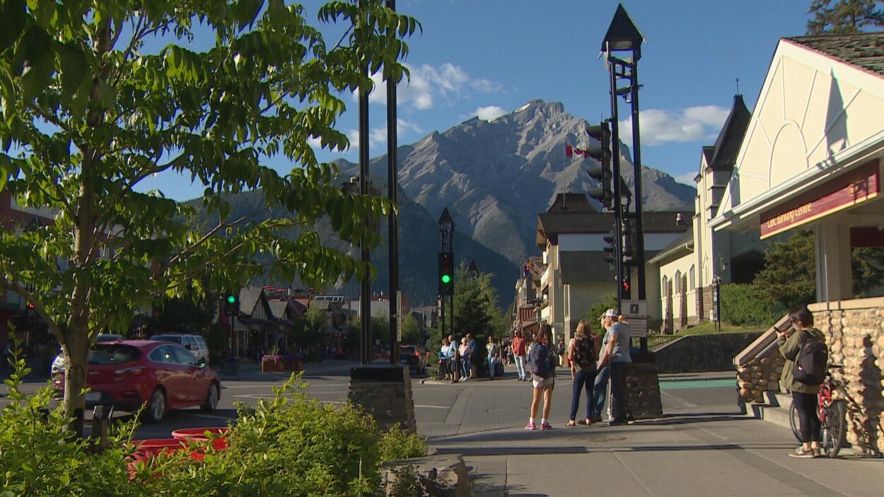 Quelques personnes attendant que le feu de circulation change pour traverser une intersection à Banff.