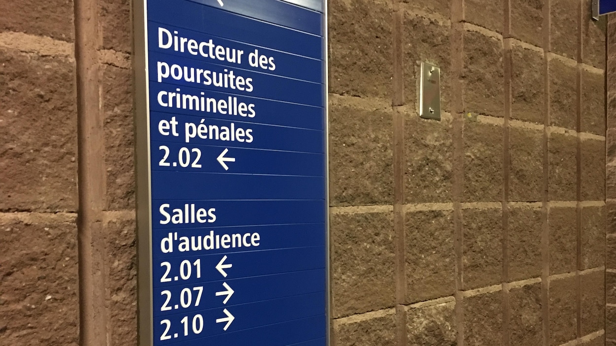 Panneau d'indication sur un mur du palais de justice de Chicoutimi indiquant la direction à prendre pour les bureaux du directeur des poursuites criminelles et pénales Panneau d'indication sur un mur du palais de justice de Chicoutimi indiquant la direction à prendre pour les bureaux du directeur des poursuites criminelles et pénales