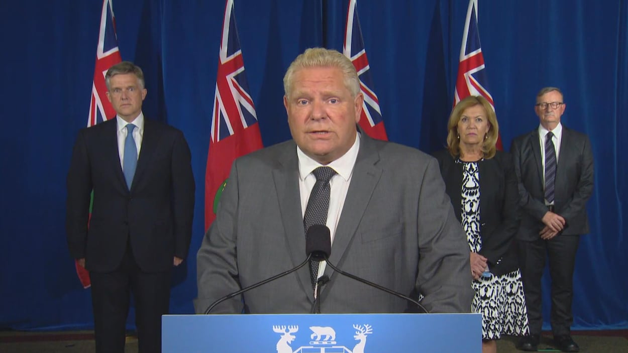 Le premier ministre de l'Ontario, Doug Ford, accompagné des ministres de la Santé, Christine Elliott et des Finances, Rod Philipps, ainsi que du médecin hygiéniste en chef de l'Ontario, le Dr David Williams, lors d'une conférence de presse lundi après-midi.