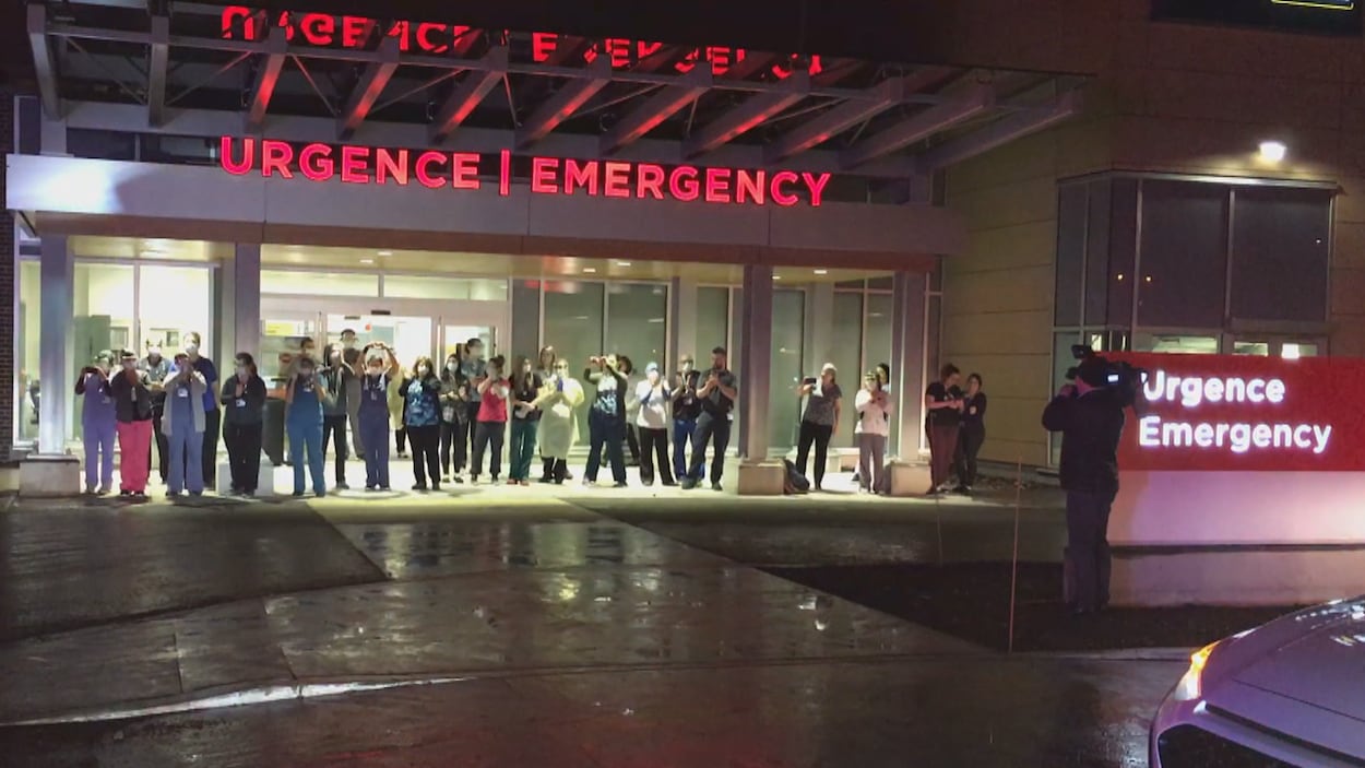 Des membres du personnel hospitalier devant la porte de l'urgence d'Hawkesbury.