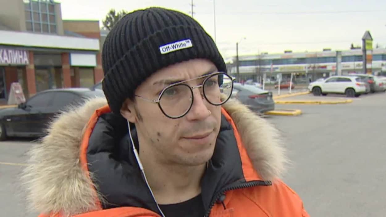 Il est en entrevue dans un stationnement.