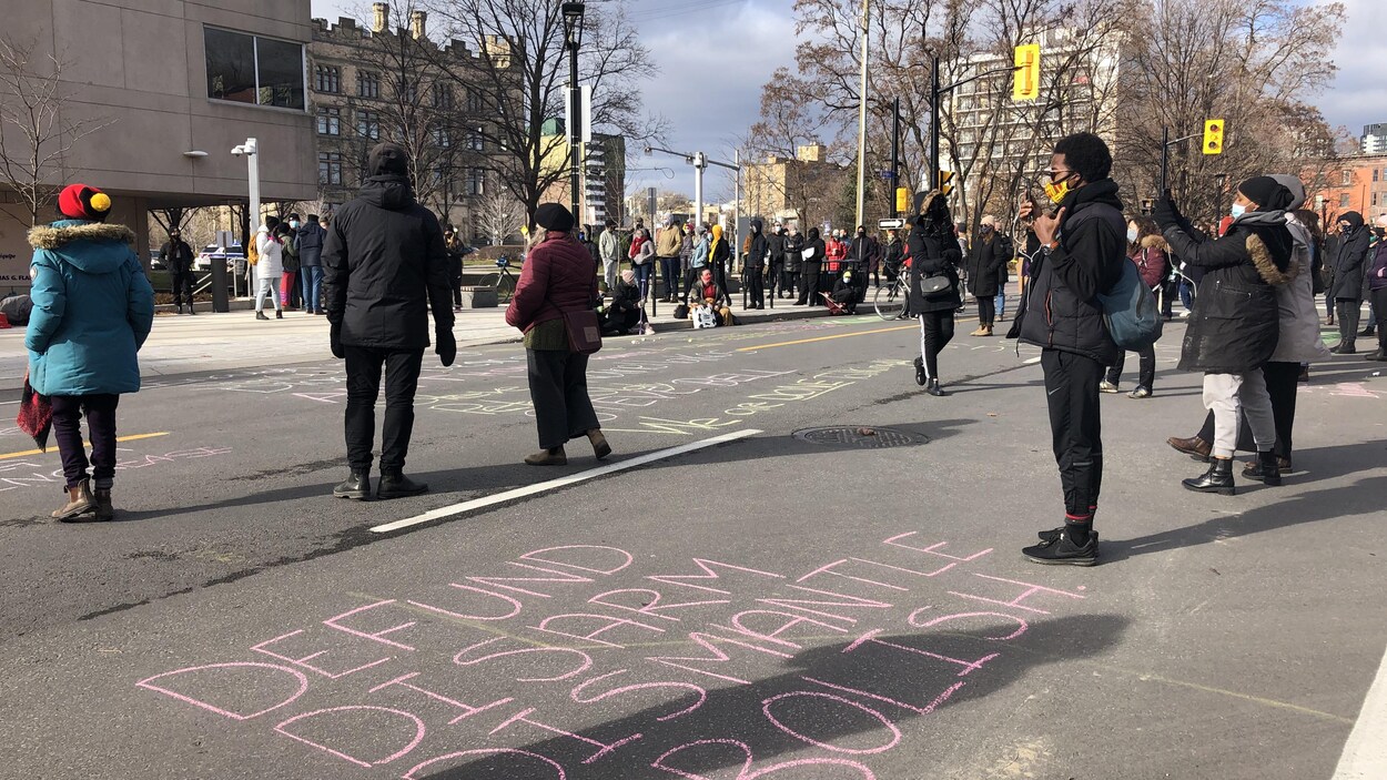 Des manifestants devant le quartier général du Service de police d'Ottawa sur la rue Elgin.