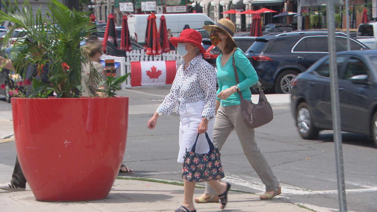 Deux femmes portant un masque marchent dans la rue à Ottawa.