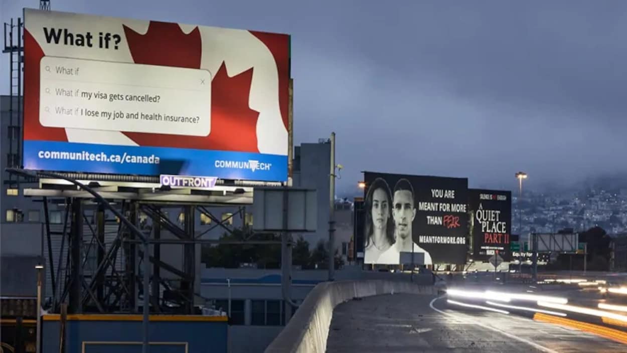 Un panneau publicitaire est éclairé au bord d'une autoroute.