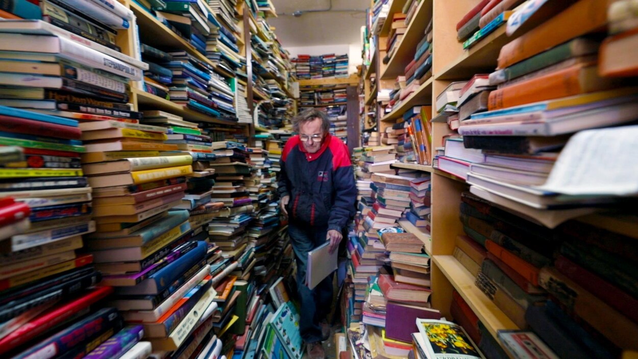 Le libraire Ralph Crawford, travail dans un environnement très étroit de sa librairie entourée de milliers de livres.