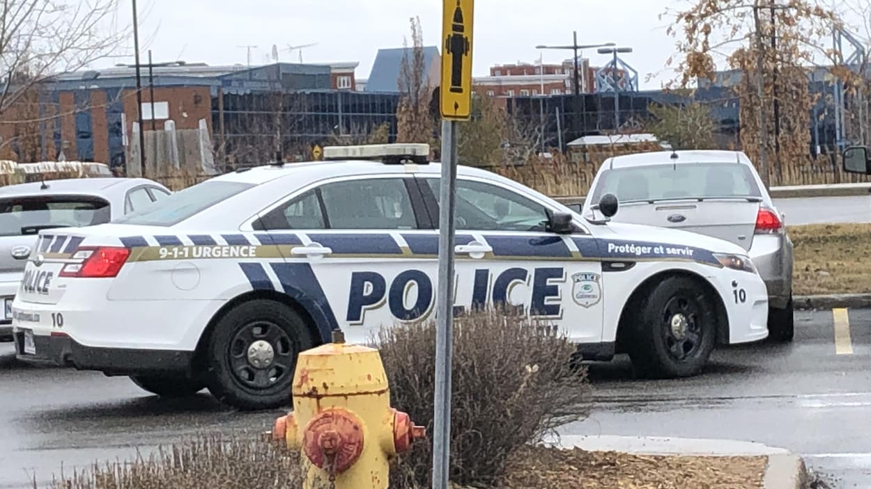 Une voiture de police dans un stationnement d'épicerie