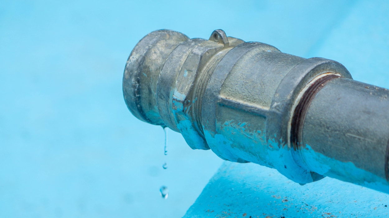 Un tuyau d'eau remplit une piscine.