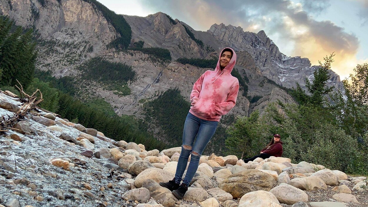 Dionne Durocher se tient sur des rochers devant une montagne.
