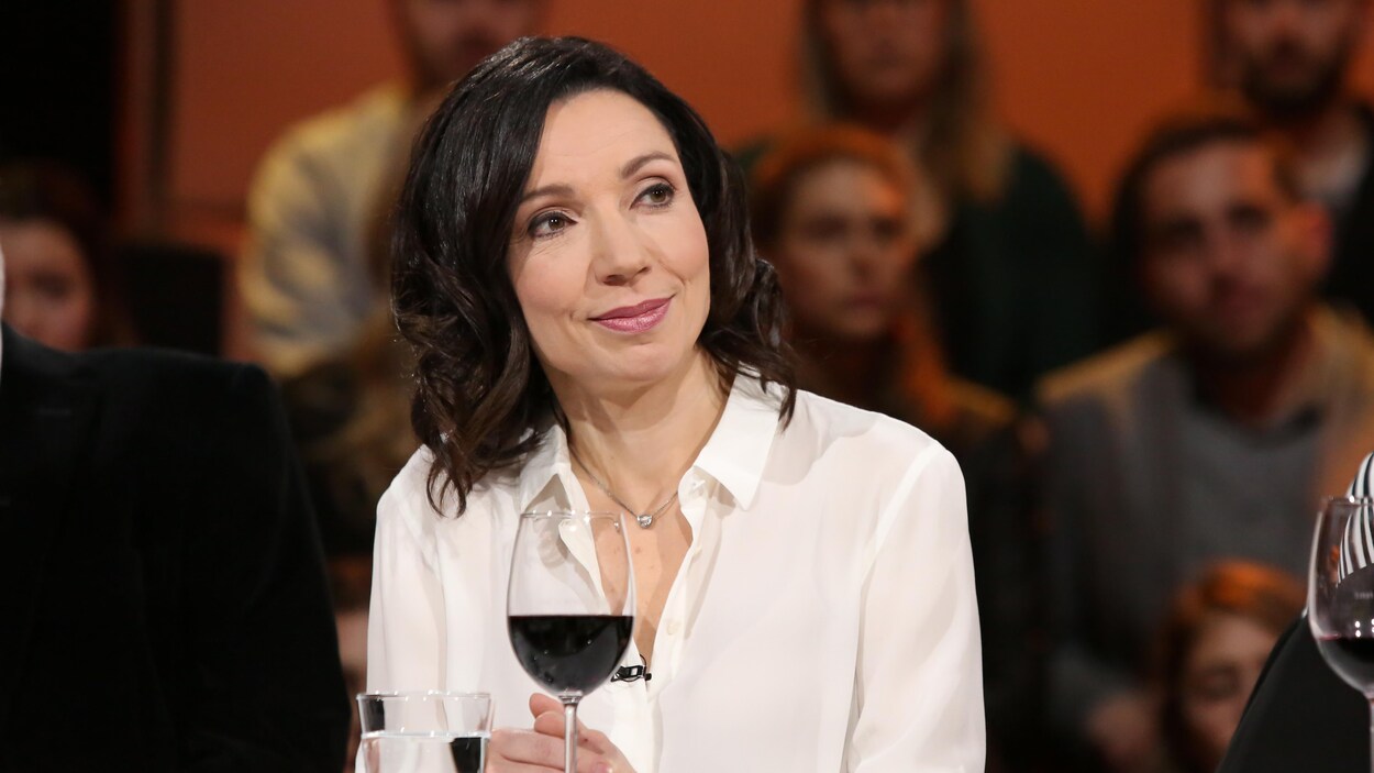 Elle porte un chemisier blanc.