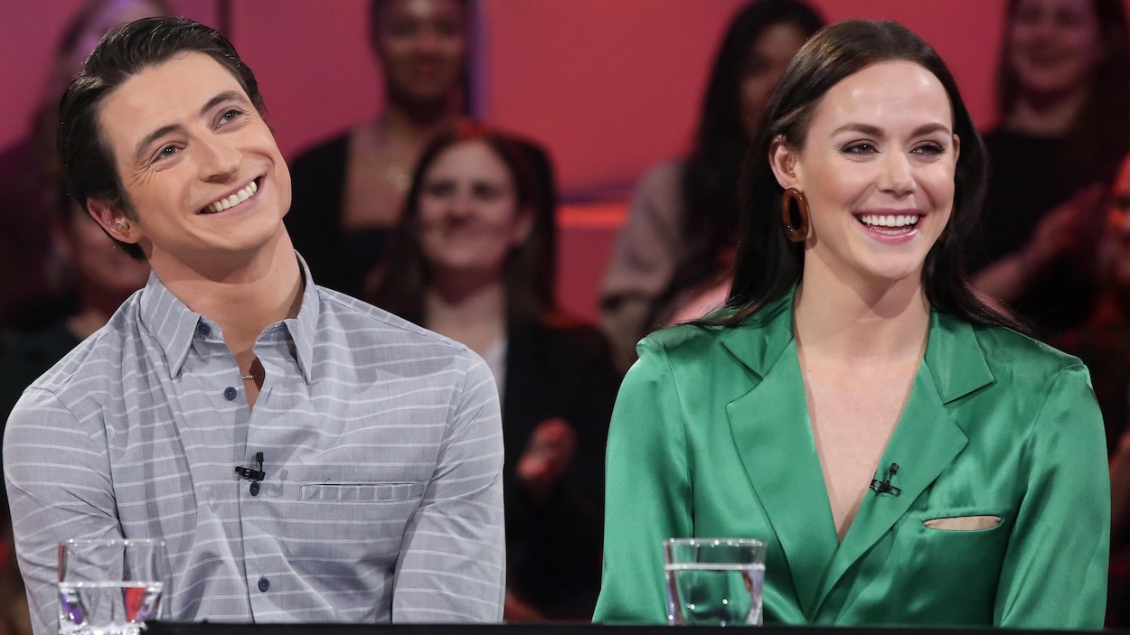 Ils sont souriants. Scott porte une chemise grise et Tessa une robe verte. Ils sont souriants. Scott porte une chemise grise et Tessa une robe verte.