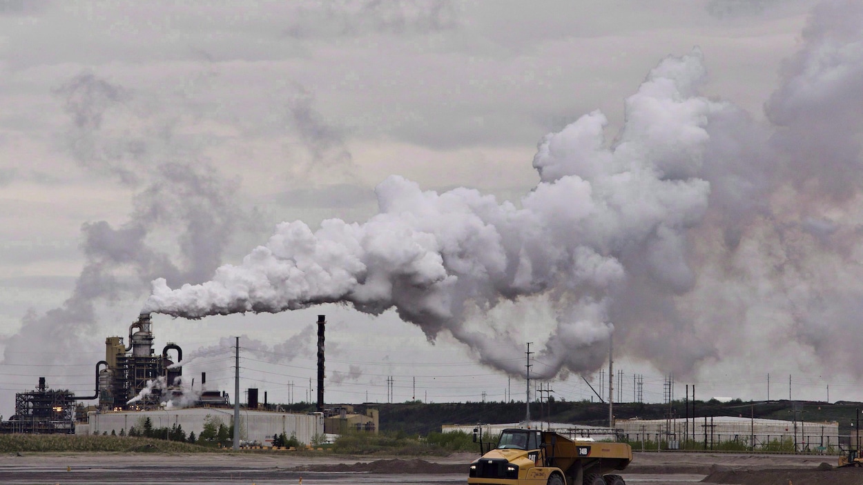 Un camion travaille près de l'installation d'extraction des sables bitumineux de Syncrude près de la ville de Fort McMurray, en Alberta, le 1er juin 2014.