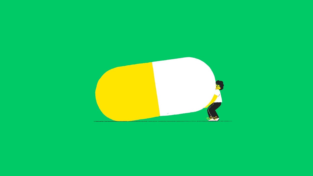 Une illustration d'un homme qui soulève une gigantesque pilule bicolore. 